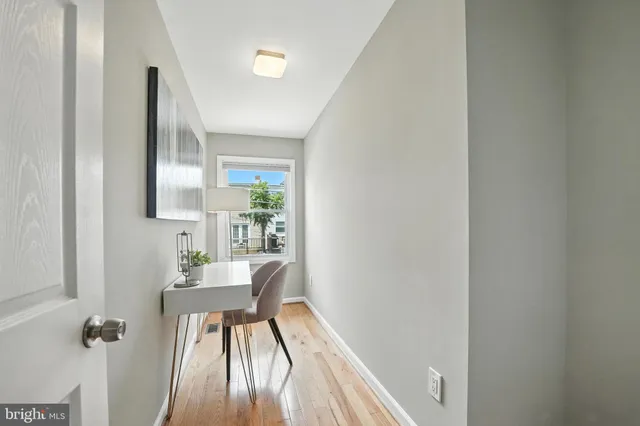 a view of a hallway with furniture and wooden floor