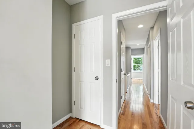 a view of a hallway with wooden floor
