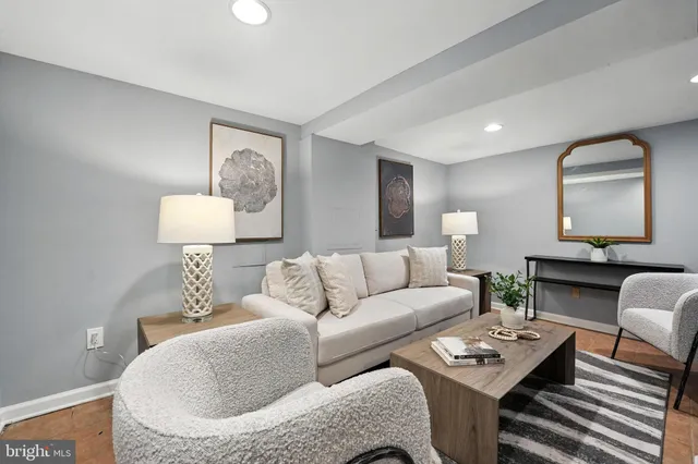 a living room with furniture a lamp and a potted plant