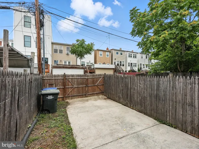 a view of a patio with table and chairs and wooden fence