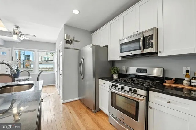 a kitchen with stainless steel appliances granite countertop a stove a refrigerator and a microwave