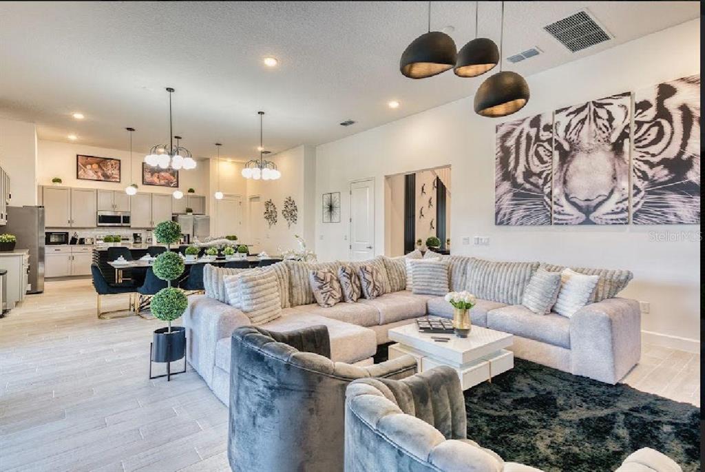 6301 Sand Skipper Road Orlando, FL 32821 - Photo 11 of 80 a living room with furniture kitchen view and a chandelier