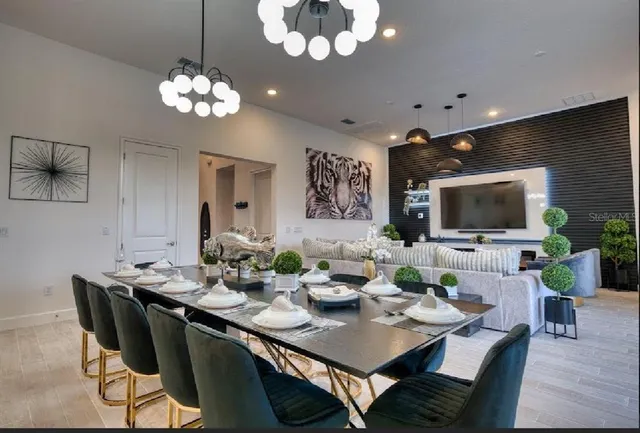 a kitchen with stainless steel appliances kitchen island granite countertop a refrigerator a stove a microwave oven a sink with island and chairs