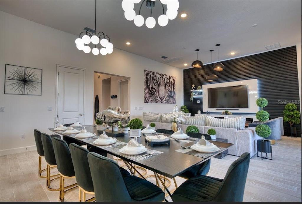 6301 Sand Skipper Road Orlando, FL 32821 - Photo 14 of 80 a view of a dining room with furniture a chandelier and wooden floor