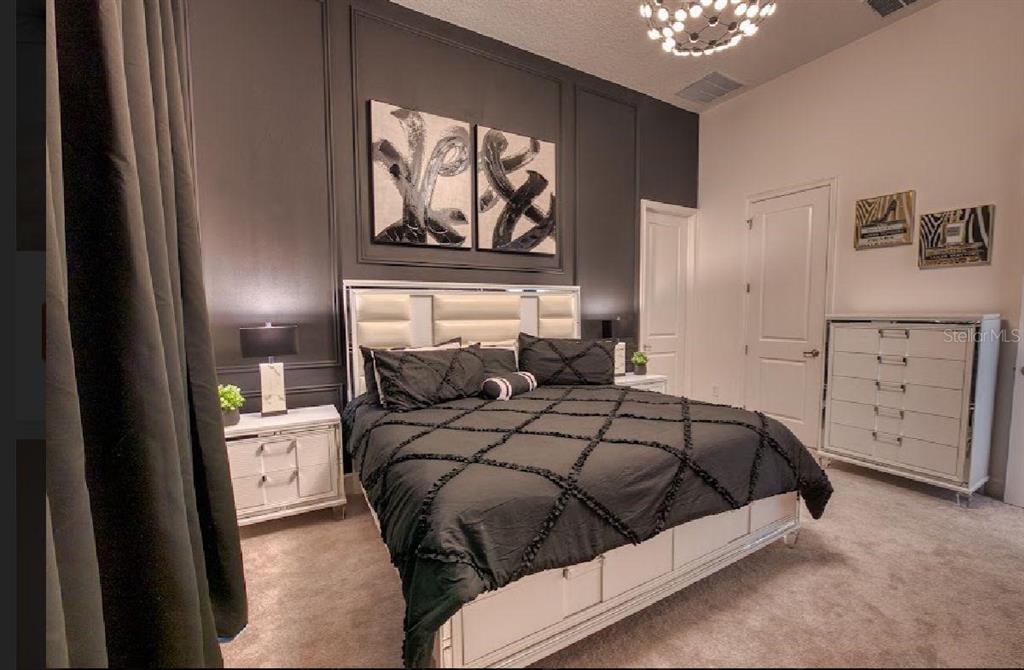 6301 Sand Skipper Road Orlando, FL 32821 - Photo 19 of 80 a bedroom with a bed and a painting on the wall