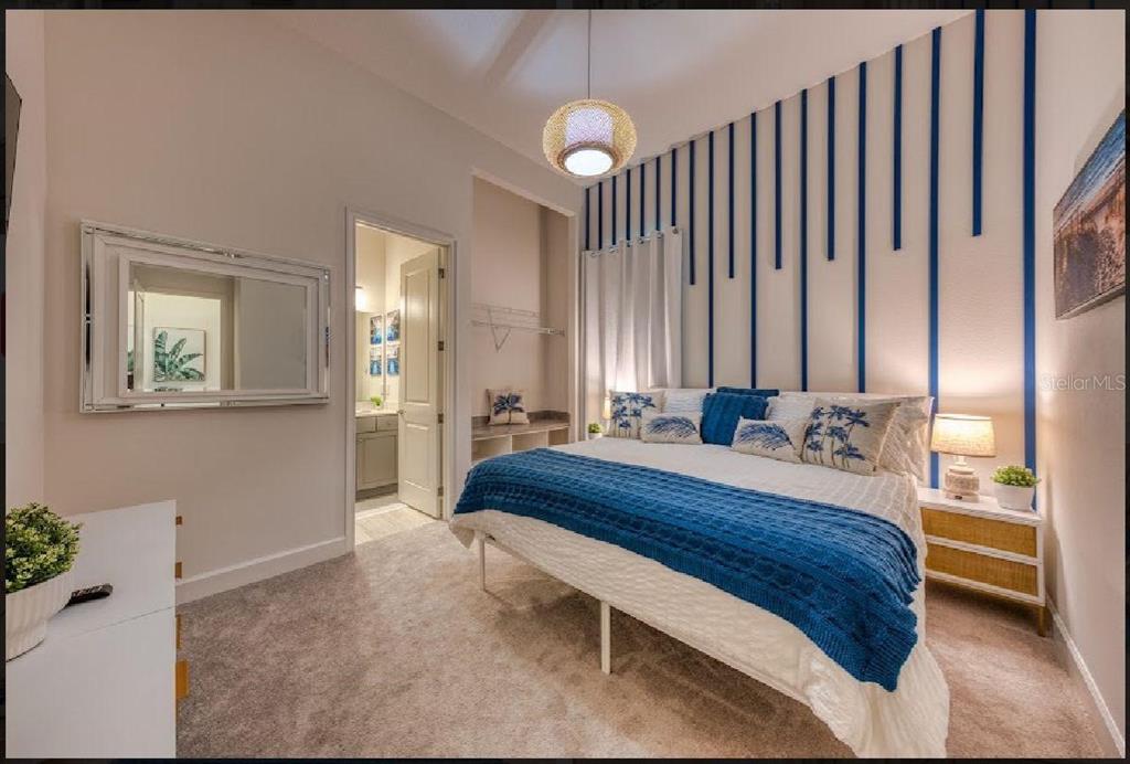 6301 Sand Skipper Road Orlando, FL 32821 - Photo 23 of 80 a bedroom with a bed and a chandelier