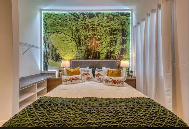 a bed sitting in a bedroom next to a window