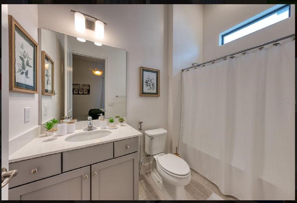 6301 Sand Skipper Road Orlando, FL 32821 - Photo 27 of 80 a bathroom with a sink a toilet and shower curtain