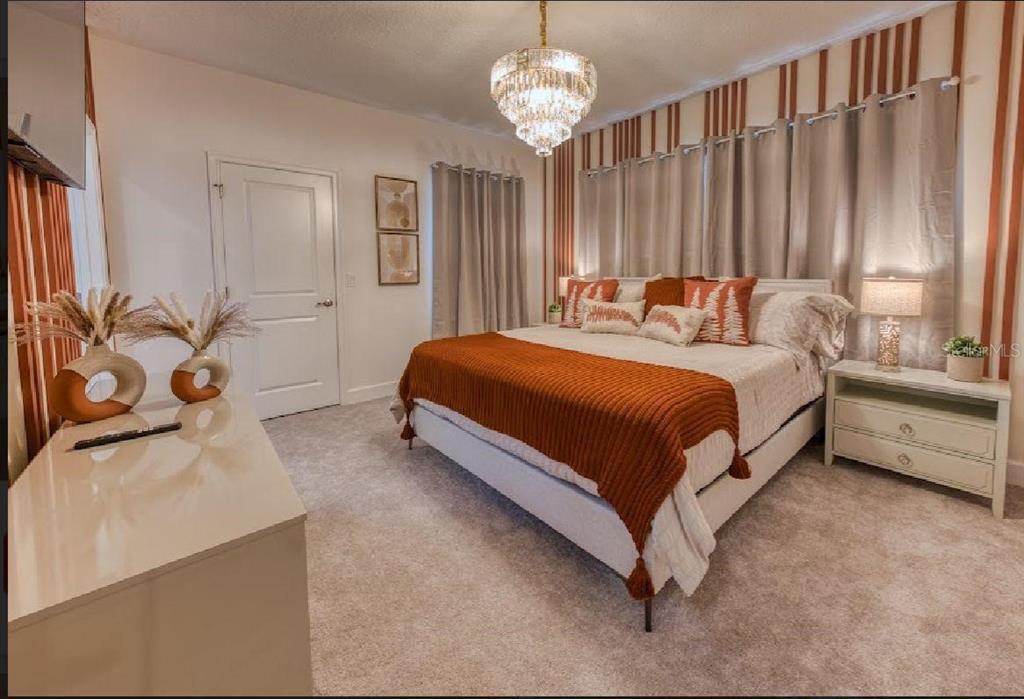 6301 Sand Skipper Road Orlando, FL 32821 - Photo 35 of 80 a bedroom with a bed and a chandelier