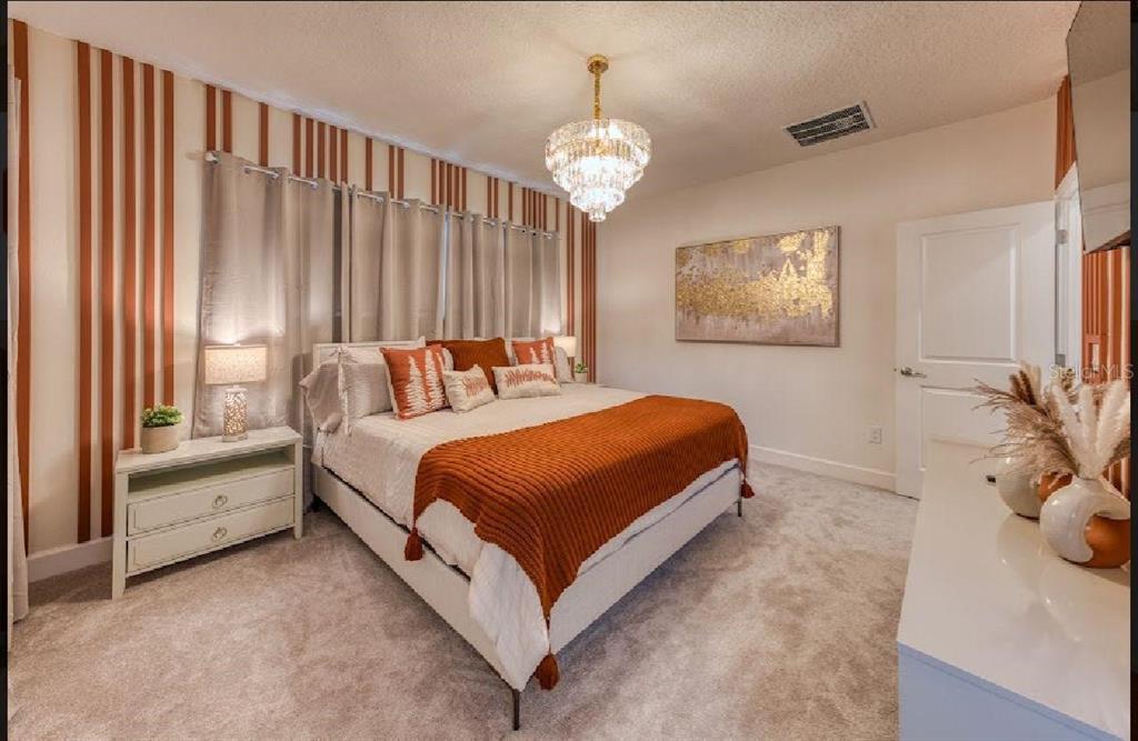 6301 Sand Skipper Road Orlando, FL 32821 - Photo 36 of 80 a bedroom with a bed and a chandelier
