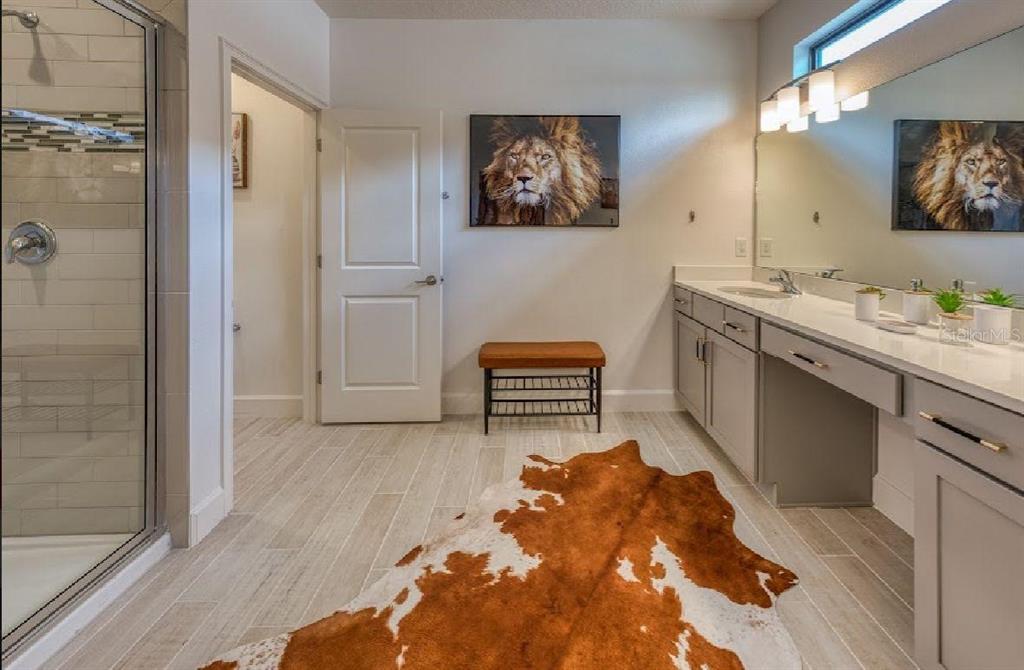 6301 Sand Skipper Road Orlando, FL 32821 - Photo 38 of 80 a spacious bathroom with a double vanity sink and a mirror