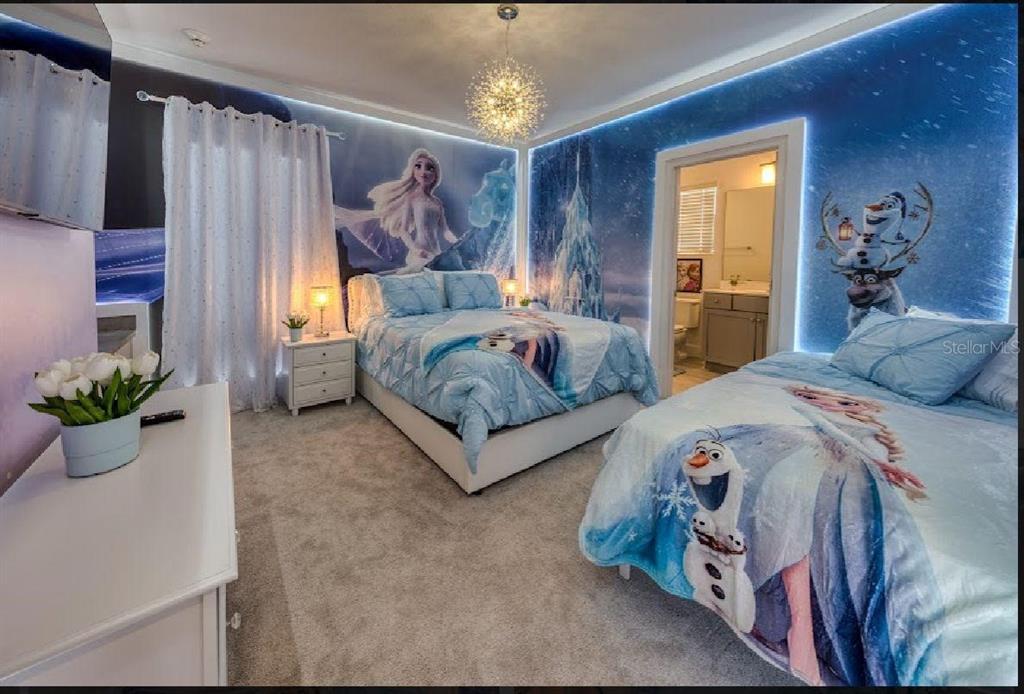 6301 Sand Skipper Road Orlando, FL 32821 - Photo 39 of 80 a spacious bedroom with a bed and a chandelier