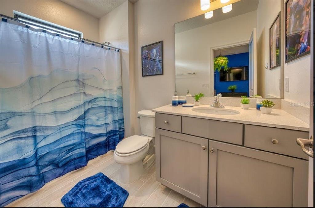 6301 Sand Skipper Road Orlando, FL 32821 - Photo 63 of 80 a bathroom with a sink toilet a mirror and shower