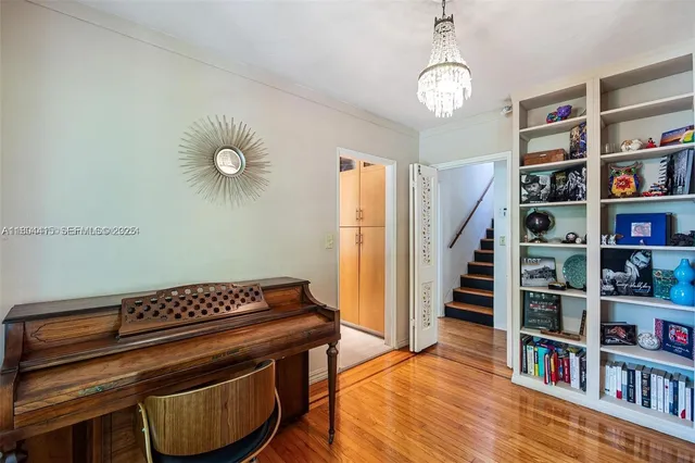 a view of room with book shelf and wooden floor