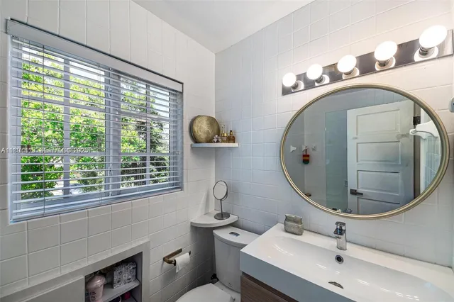 a bathroom with a sink mirror and toilet