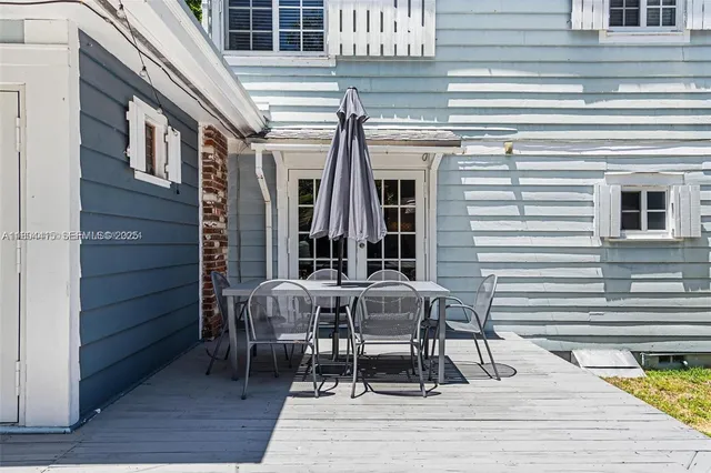 a view of a patio with table and chairs and wooden floor