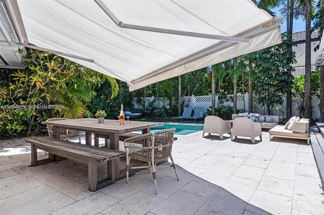 a view of a patio with a dining table and chairs with wooden floor and fence