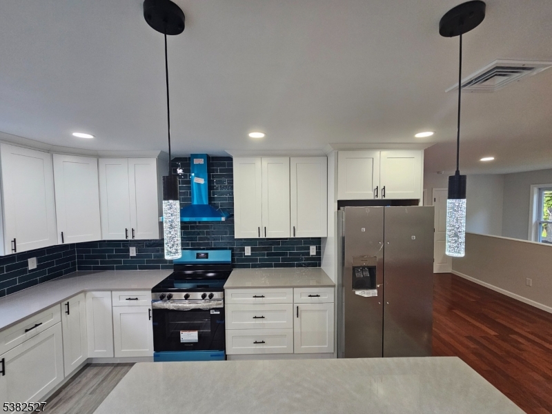 43 Rockport Road Wantage, NJ 07461 - Photo 14 of 30 a kitchen with stainless steel appliances granite countertop a stove a refrigerator and a sink with wooden floor
