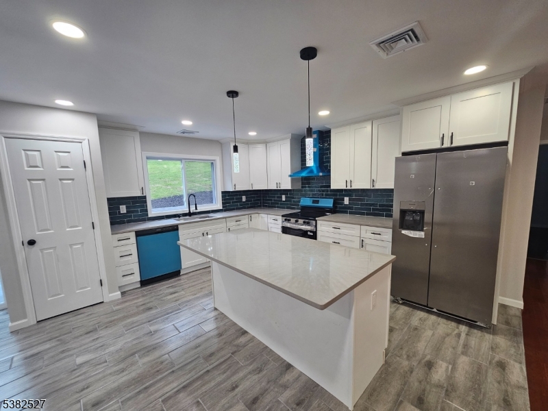43 Rockport Road Wantage, NJ 07461 - Photo 15 of 30 a large kitchen with stainless steel appliances granite countertop a refrigerator a sink dishwasher a stove and white countertops with wooden floor