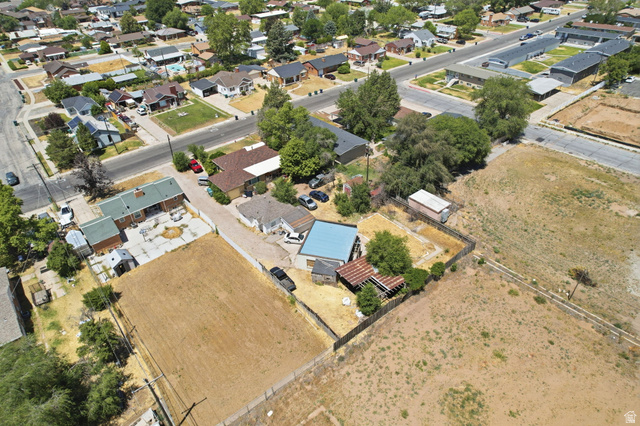 5480 South 2000th Street West Roy, UT 84067 - Photo 36 of 36 Aerial perspective showcasing a residential property with a partial fence perimeter, mature trees, and a detached structure