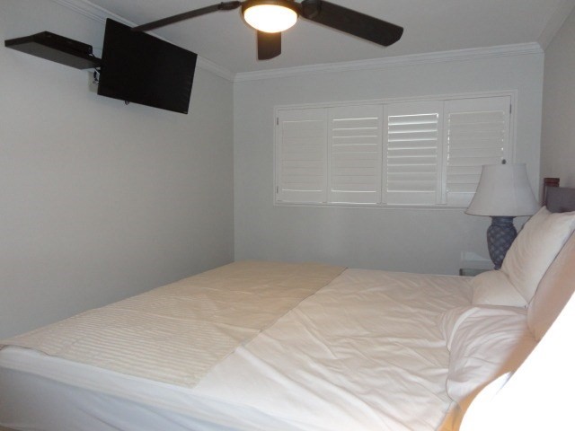 5050 Lawai Road, Unit 101 Koloa, HI 96756 - Photo 15 of 24 a bedroom with a bed and a flat screen tv