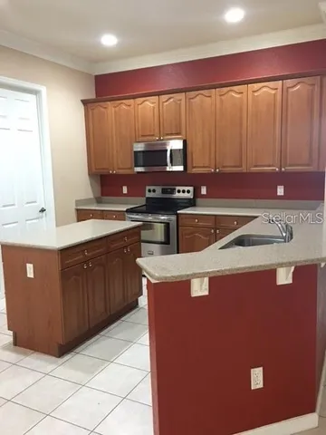 a kitchen with kitchen island granite countertop a sink counter top space and a stove top oven