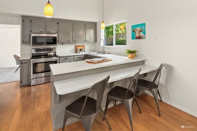 a kitchen with a table chairs sink and cabinets