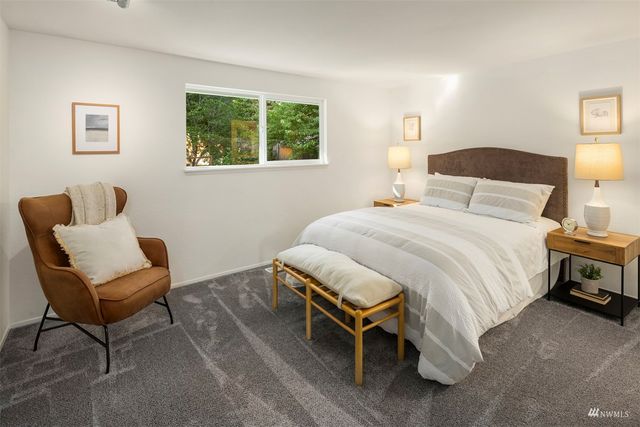 a bedroom with a bed chair and window