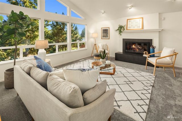 a living room with furniture a fireplace and a large window
