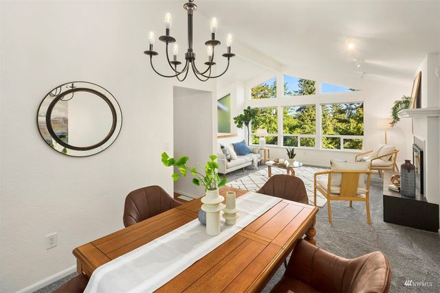 a view of a dining room with furniture a chandelier and wooden floor