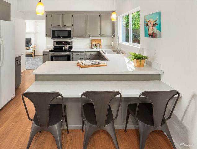 a kitchen with stainless steel appliances a dining table chairs and a refrigerator