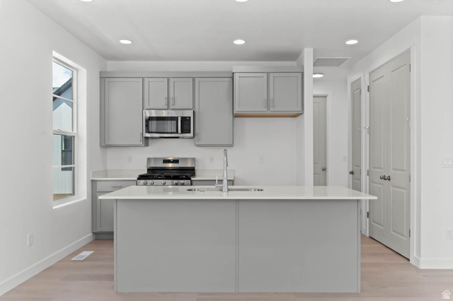 3204 West 1570 North Provo, UT 84601 - Photo 12 of 19 Kitchen with stainless steel appliances, gray cabinetry, a center island with sink, recessed lighting, and light wood-type flooring