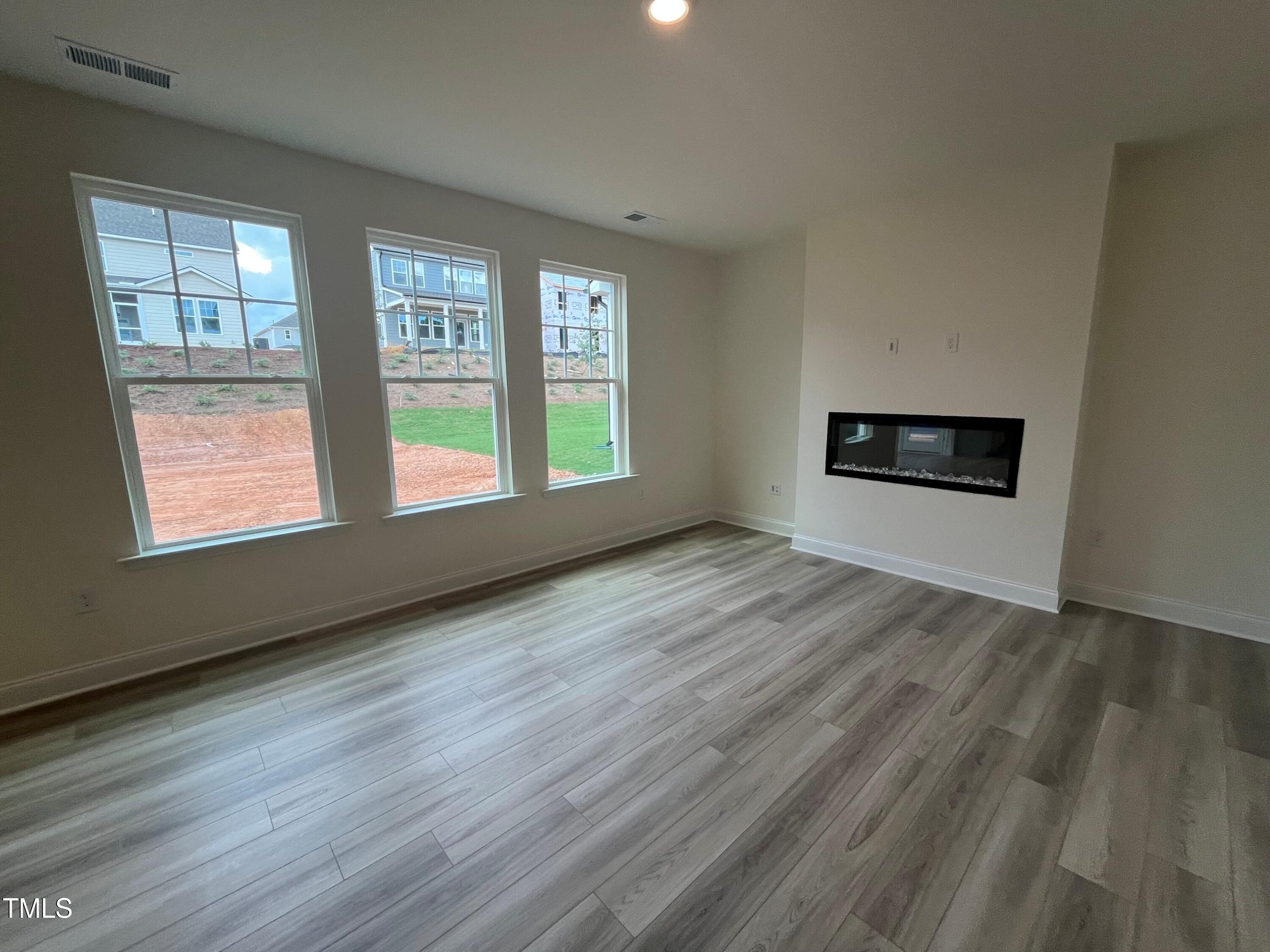 779 Old Station Pointe Angier, NC 27501 - Photo 12 of 33 an empty room with wooden floor and windows