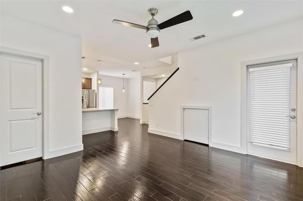 5924 Hudson Street, Unit F Dallas, TX 75206 - Photo 9 of 25 a view of a livingroom with wooden floor a ceiling fan and windows