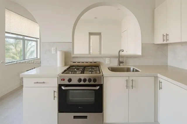 a white stove top oven sitting inside of a kitchen