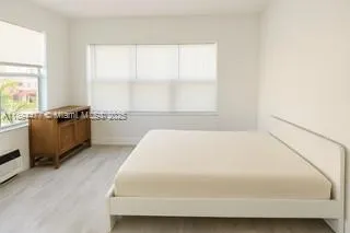 a large bed sitting in a room next to a window