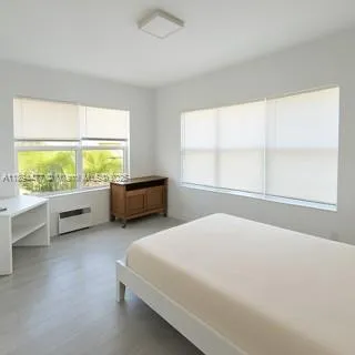 a bedroom with a bed and a large window