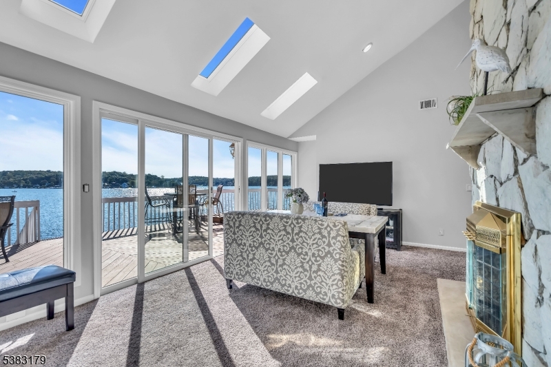 11 Bass Rock Road Hopatcong, NJ 07843 - Photo 17 of 50 a living room with furniture a flat screen tv and a floor to ceiling window