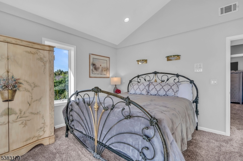 11 Bass Rock Road Hopatcong, NJ 07843 - Photo 22 of 50 a bed sitting in a bedroom next to a window and a chandelier