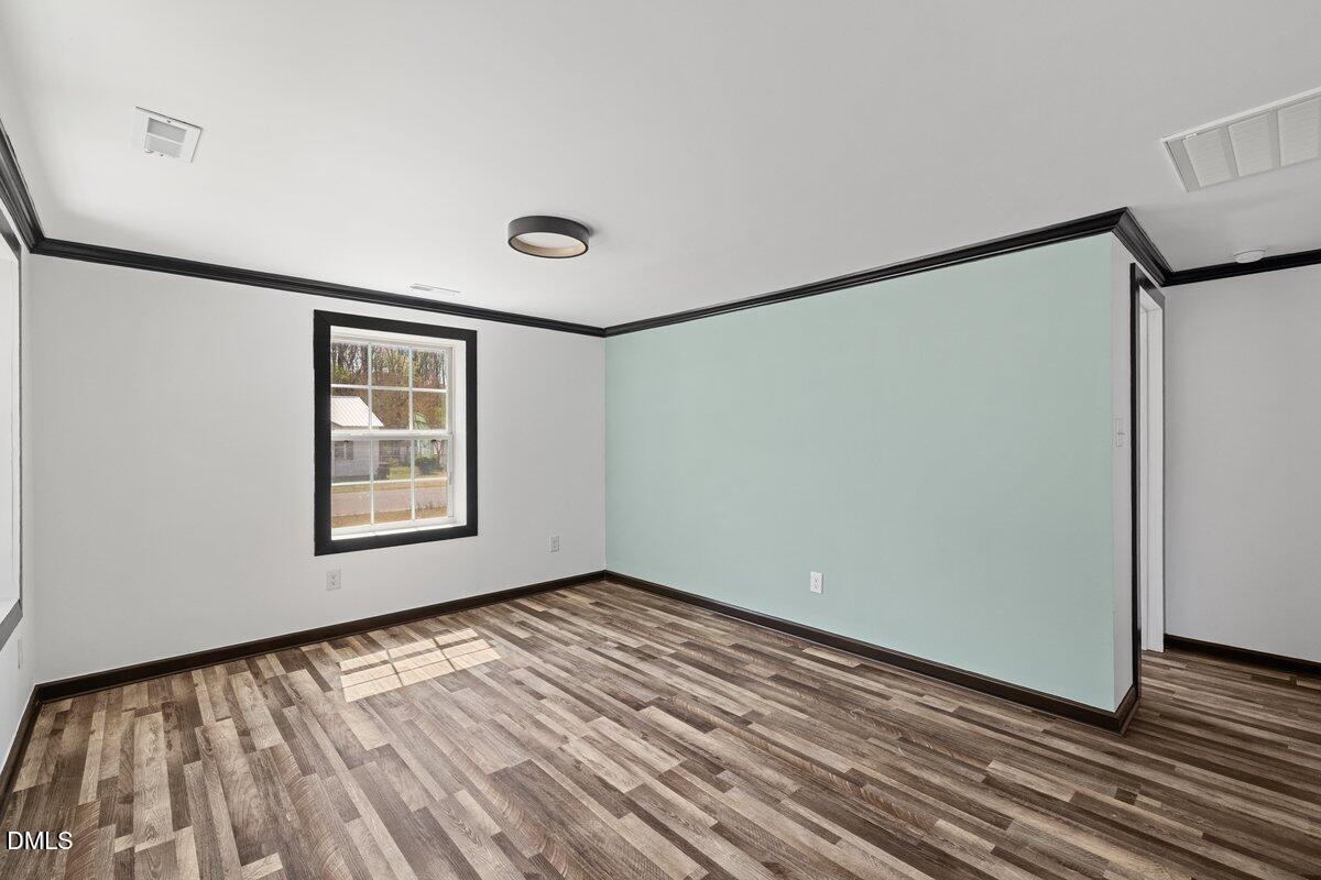 601 Temple Street Selma, NC 27576 - Photo 10 of 13 a view of an empty room with wooden floor and a window