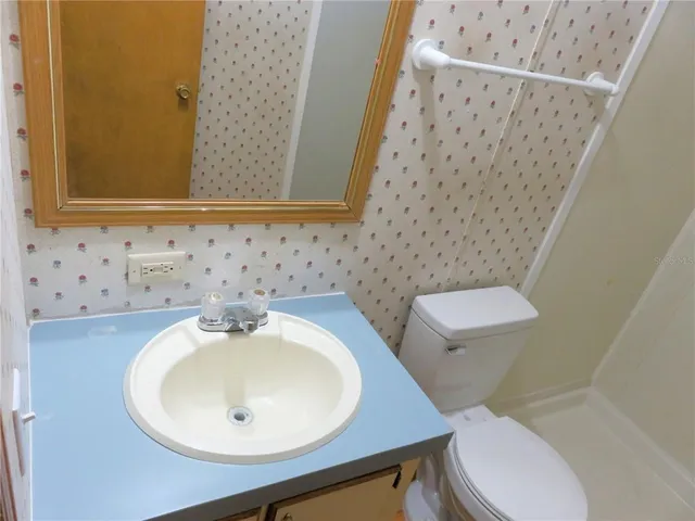 a bathroom with a sink toilet and mirror