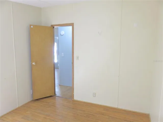a view of an empty room with closet and a window