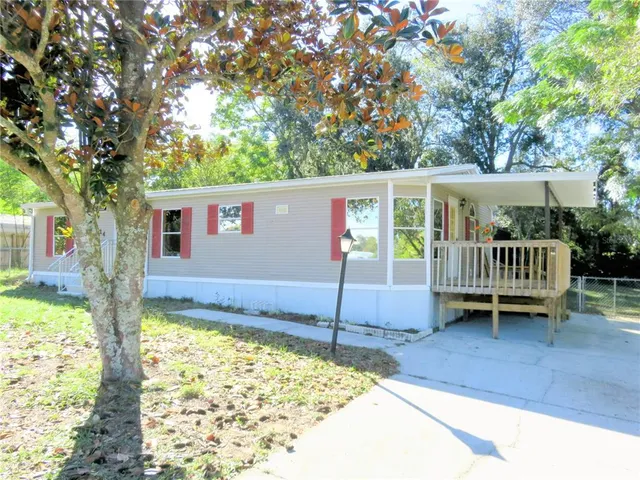 a view of a house with a wooden deck and a yard