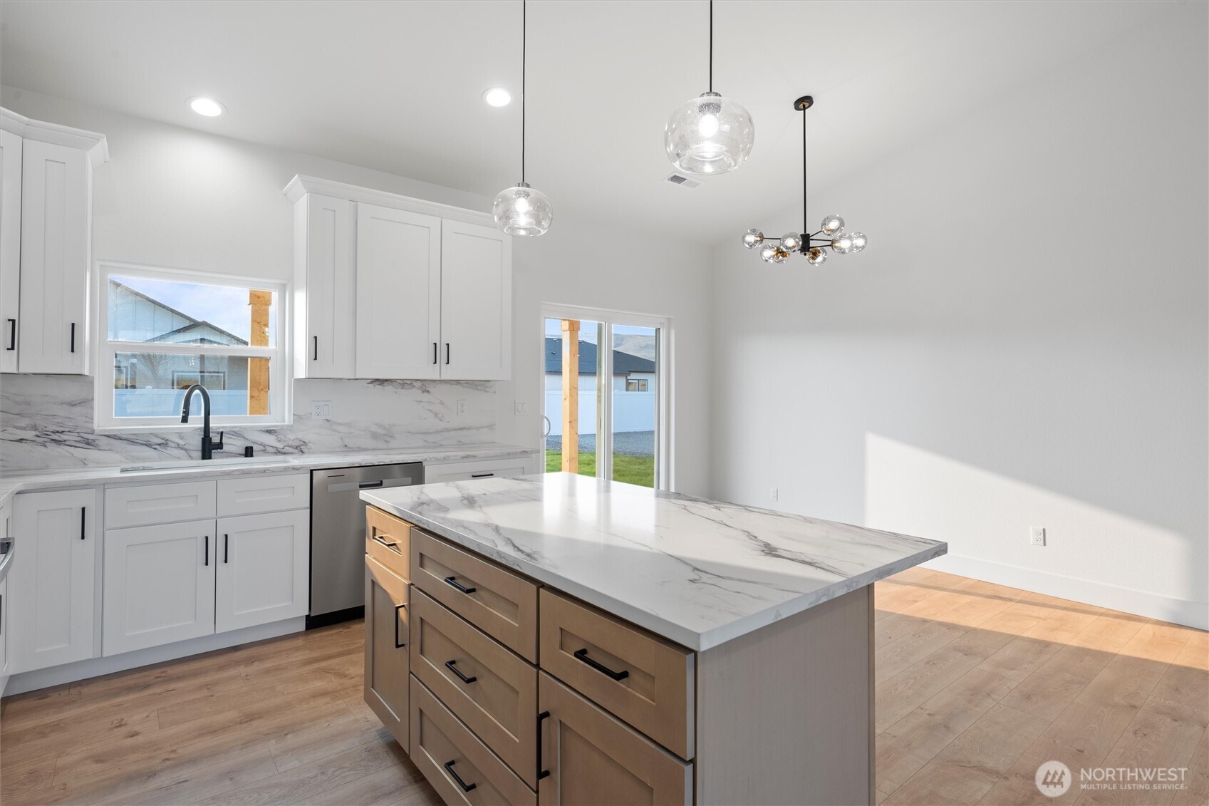 2391 Hunters Street Ephrata, WA 98823 - Photo 12 of 40 a kitchen with a sink a center island a stove and a wooden floor