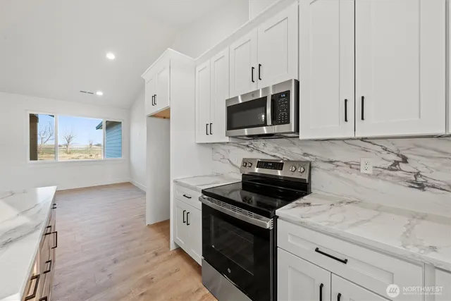 a view of a kitchen with white cabinets