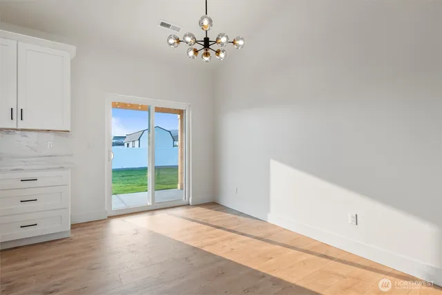 a kitchen with stainless steel appliances granite countertop a sink a stove a refrigerator and white cabinets with wooden floor