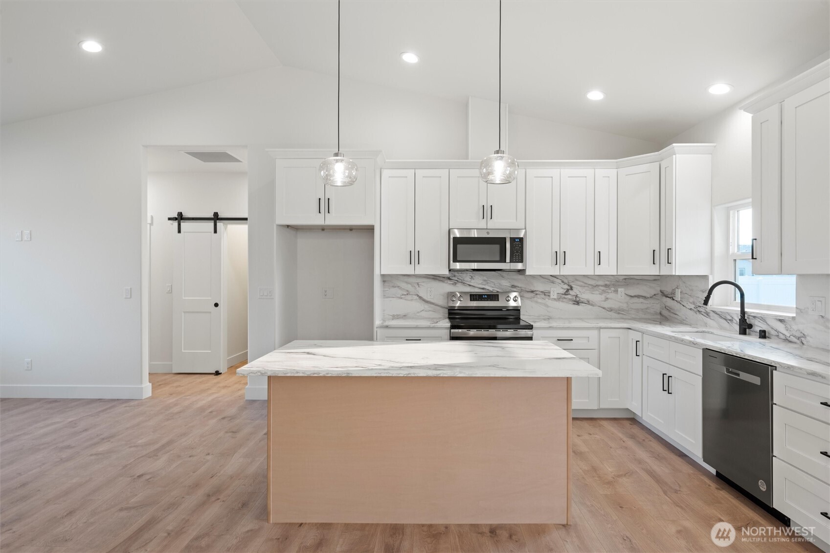 2391 Hunters Street Ephrata, WA 98823 - Photo 10 of 40 a kitchen with stainless steel appliances granite countertop a sink a stove a refrigerator and white cabinets with wooden floor