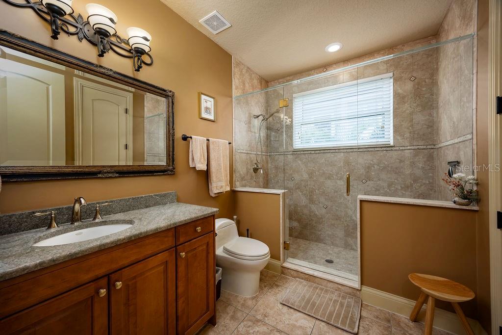 306 Harbor Drive Indian Rocks Beach, FL 33785 - Photo 33 of 49 a spacious bathroom with a granite countertop sink a toilet a mirror and shower