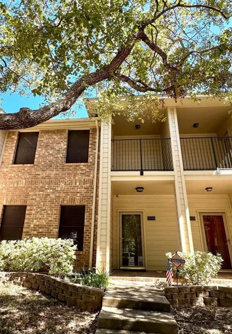 a front view of a house with a tree