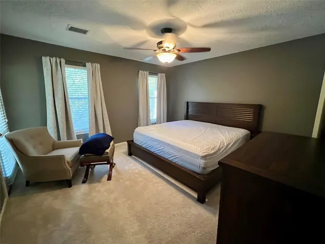 a bedroom with a bed chair and a chandelier
